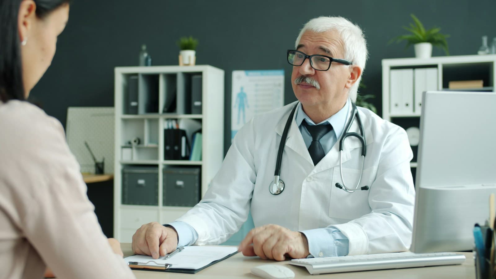 A physician talking with a patient in a bright consulting room